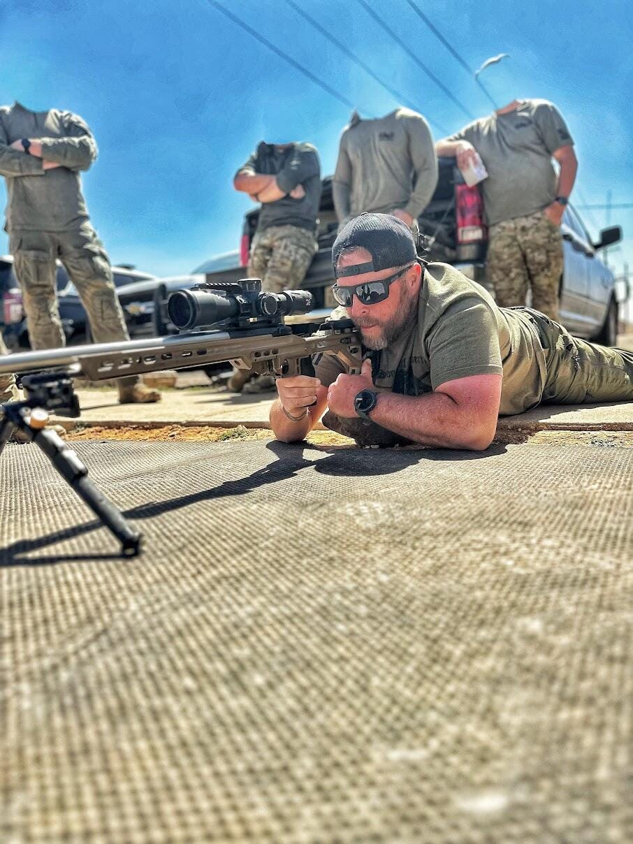 Students training with precision rifles on a covered firing line